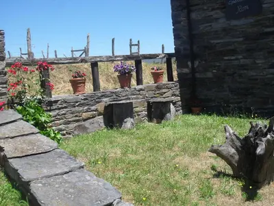 a stone wall with potted plants and flowers on it at Apartamentos Rurales RON in Ron