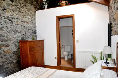 a bedroom with a bathroom with a toilet in it at Apartamentos Rurales RON in Ron