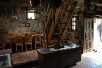 a room with a staircase and a kitchen with tables and chairs at Laventanadetorre in Torre de Babia