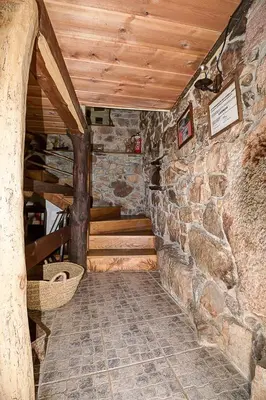 a room with a stone wall and wooden ceiling at Laventanadetorre in Torre de Babia
