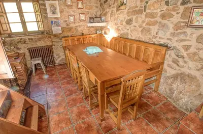a dining room with a wooden table and chairs at Laventanadetorre in Torre de Babia