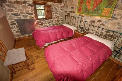 a room with three beds with pink blankets in it at Laventanadetorre in Torre de Babia