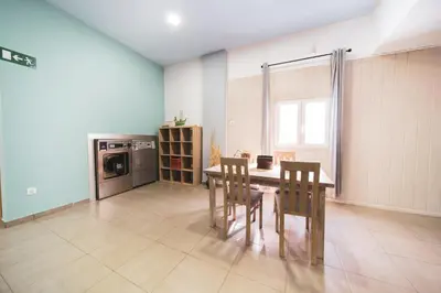 a kitchen with a table and chairs and a microwave at Albergue Barullo - Cubículos - Literas - Habitaciones in Sarria