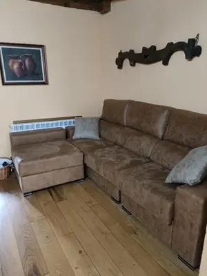 a brown couch sitting in a living room at Casa do Eiró in Lago de Carucedo
