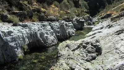 a river between some rocks and a mountain at Apartamentos Turísticos Cabrera in Tejedo de Ancares