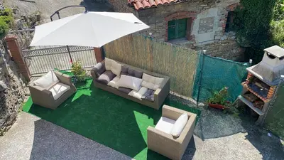 a patio with two couches and an umbrella at Casa Rural La Corrada in Llamoso