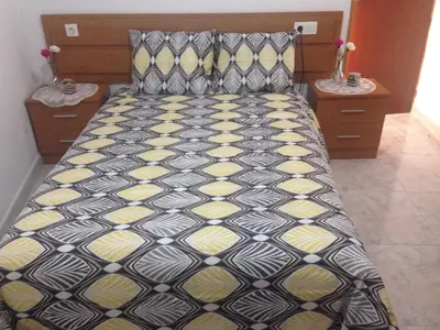 a bed with a black and yellow comforter in a bedroom at Casa Rural La Corrada in Llamoso