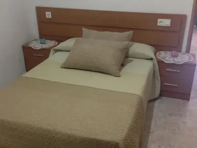 a bedroom with a large bed with two nightstands at Casa Rural La Corrada in Llamoso