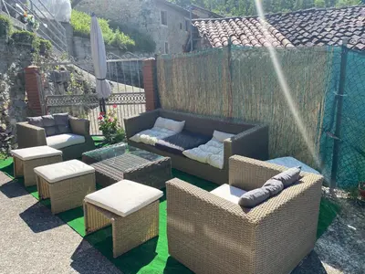 a patio with chairs and couches and a water fountain at Casa Rural La Corrada in Llamoso