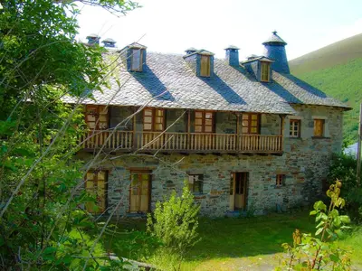 an old stone house with a balcony on top of it at El Rincón del Cuco in Tejedo de Ancares
