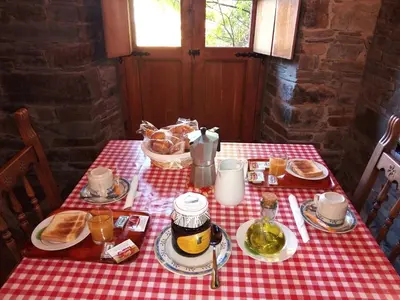 a table with a red and white checkered table cloth at El Rincón del Cuco in Tejedo de Ancares