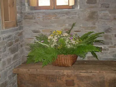 a basket of flowers sitting on top of a table at El Rincón del Cuco in Tejedo de Ancares