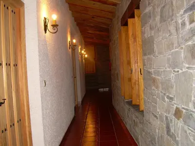 a hallway in a house with a stone wall at El Rincón del Cuco in Tejedo de Ancares