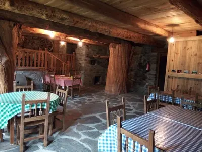 a dining room with tables and chairs in a building at El Rincón del Cuco in Tejedo de Ancares