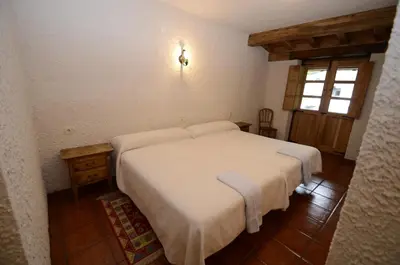 a bedroom with a white bed and a window at El Rincón del Cuco in Tejedo de Ancares