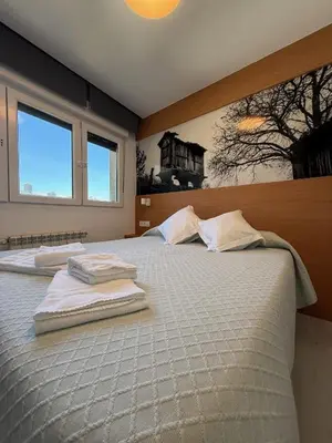 a bedroom with a large bed with towels on it at Pension Restaurante Casa Camiño in Palas de Rei
