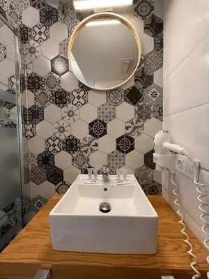a bathroom with a white sink and a mirror at Pension Restaurante Casa Camiño in Palas de Rei