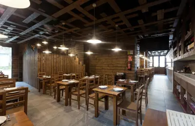a dining room with wooden tables and chairs at Pension Restaurante Casa Camiño in Palas de Rei
