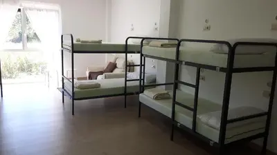 a room with three bunk beds and a couch at Albergue O Trisquel in O Pedrouzo