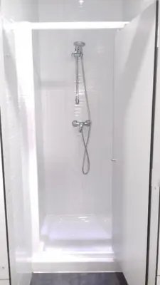 a white shower stall with a pair of scissors in it at Albergue O Trisquel in O Pedrouzo