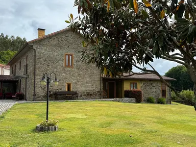 a stone house with a grass yard in front of it at Casa da Paioca in Paleo