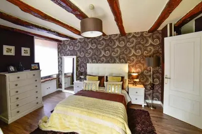 a bedroom with a bed and a wall covered in wallpaper at Casa da Xeitosa in Barbudo