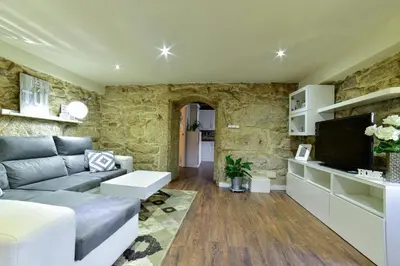 a living room with a couch and a tv at Casa da Xeitosa in Barbudo
