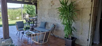 a patio with chairs and a table and plants at Casa da Xeitosa in Barbudo