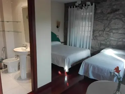 a bedroom with two beds and a sink and a mirror at Las Horas Perdidas in Moscán