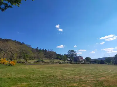 a large field with a house in the distance at Las Horas Perdidas in Moscán