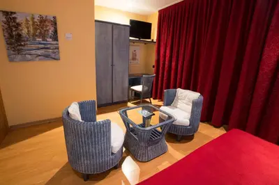 a living room with chairs and a red curtain at Motel Acropolis in Camponaraya