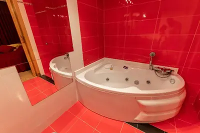 a red bathroom with a tub and a toilet at Motel Acropolis in Camponaraya