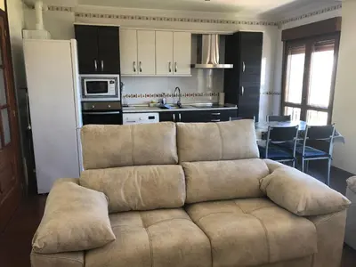 a living room with a couch and a kitchen at Apartamento Vistas al mar in Foz