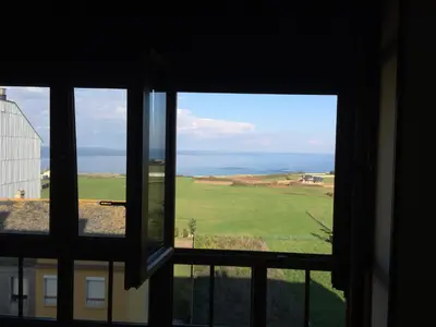 a view of the ocean from a window at Apartamento Vistas al mar in Foz