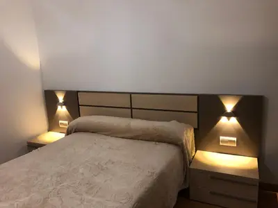 a bedroom with a bed with two lights on it at Apartamento Vistas al mar in Foz