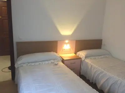 two beds in a bedroom with a lamp on a night stand at Apartamento Vistas al mar in Foz