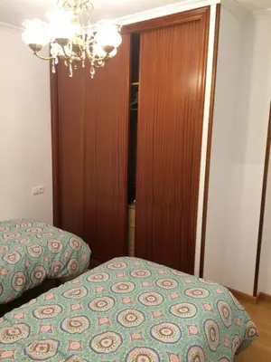 a bedroom with a bed and a wooden closet at Apartamento Vistas al mar in Foz