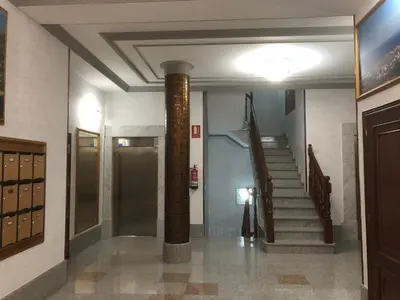 a hallway with a column and stairs in a building at Apartamento Vistas al mar in Foz