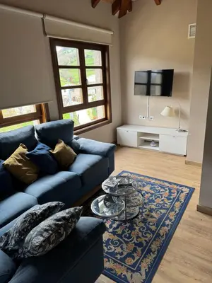 a living room with a blue couch and a table at Apartamentos Rurales Los Mazos in Boal