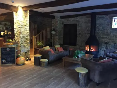 a living room with couches and a brick wall at Casa Lixa Hotel Rural Albergue in Las Herrerías