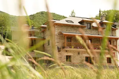 a large stone building with a balcony in a field at Casa Lixa Hotel Rural Albergue in Las Herrerías
