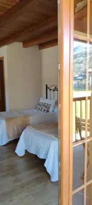 a bedroom with two beds and a balcony at Casa Lixa Hotel Rural Albergue in Las Herrerías