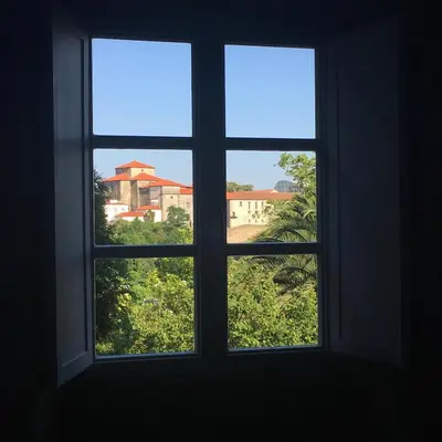 an open window with a view of a city at Pensión O Xardin de Julia in Santiago de Compostela