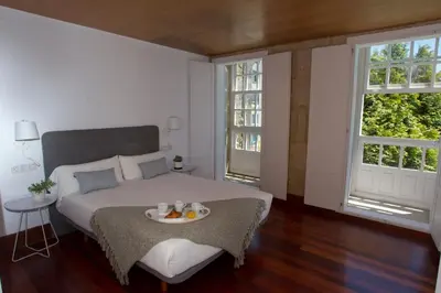 a bedroom with a bed with a tray of food on it at Pensión O Xardin de Julia in Santiago de Compostela