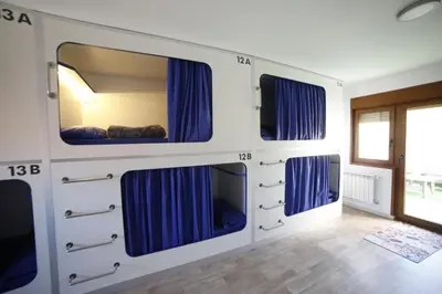 a bedroom with a bed with blue curtains at Zendoira in Palas de Rei