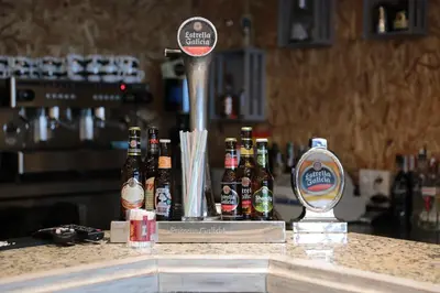 a counter with a bunch of bottles of beer at Zendoira in Palas de Rei
