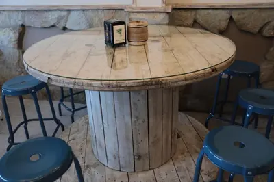 a wooden table with stools and a table with a book at Zendoira in Palas de Rei