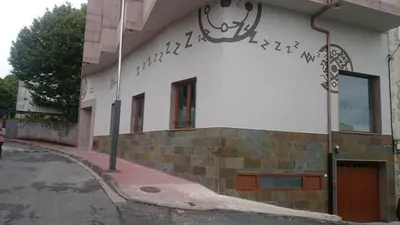 a building with writing on the side of it at Zendoira in Palas de Rei