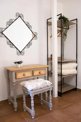 a table and a bench in a room with a mirror at Posada El Tesin in Rabanal del Camino