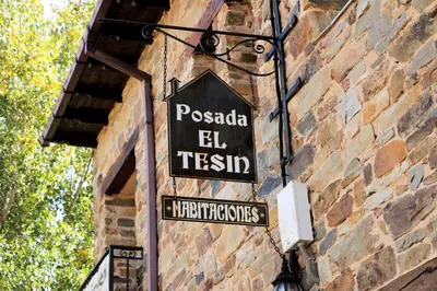 a street sign on the side of a brick building at Posada El Tesin in Rabanal del Camino